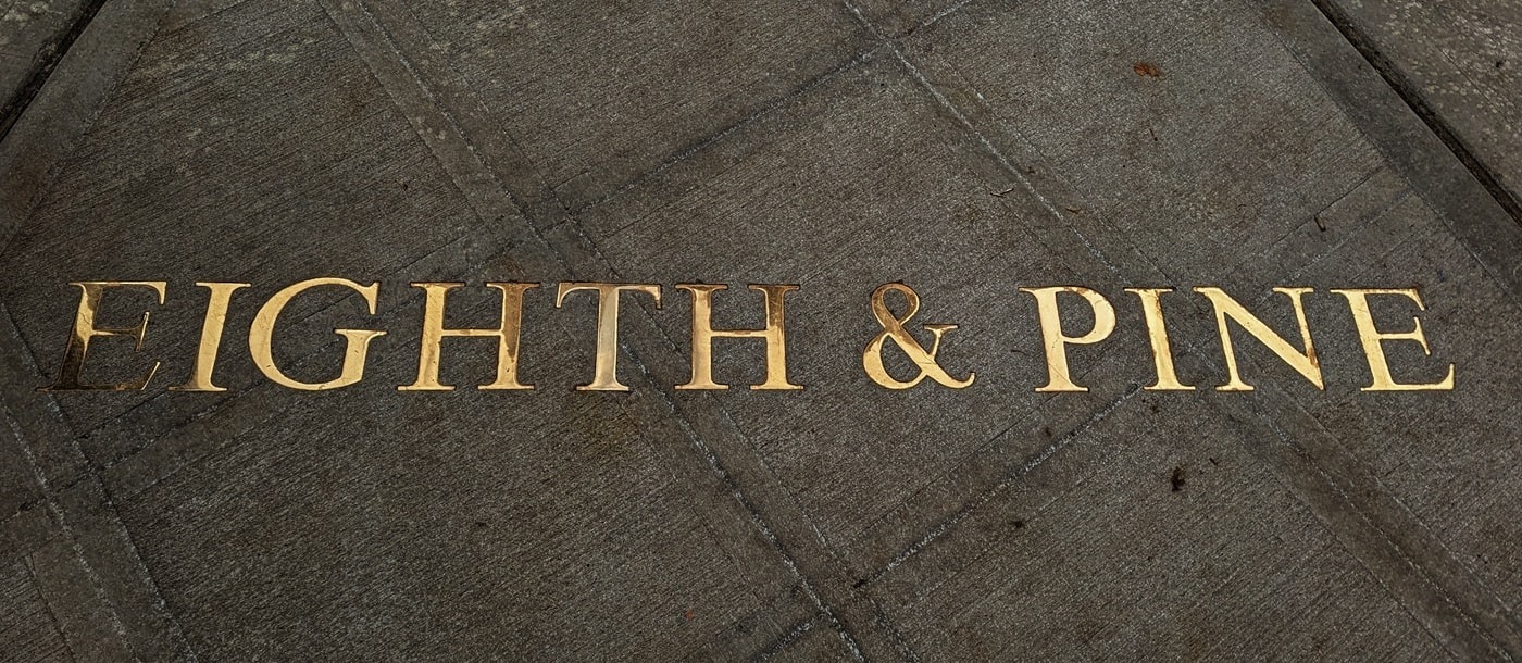 Eighth & Pine written in bronze letters on a side walk.