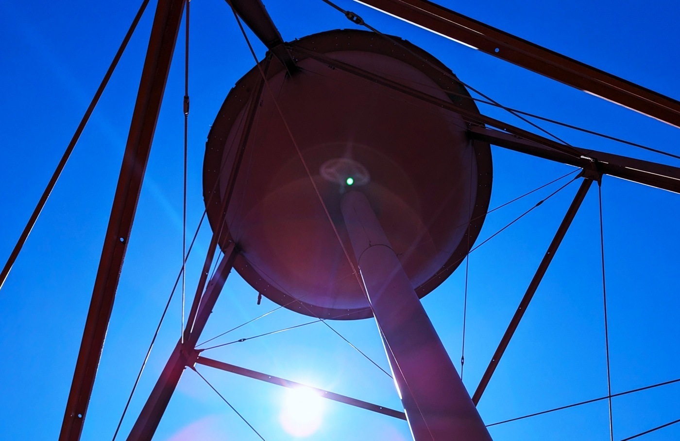 An upward view of a red water contrasted against a blue sky.