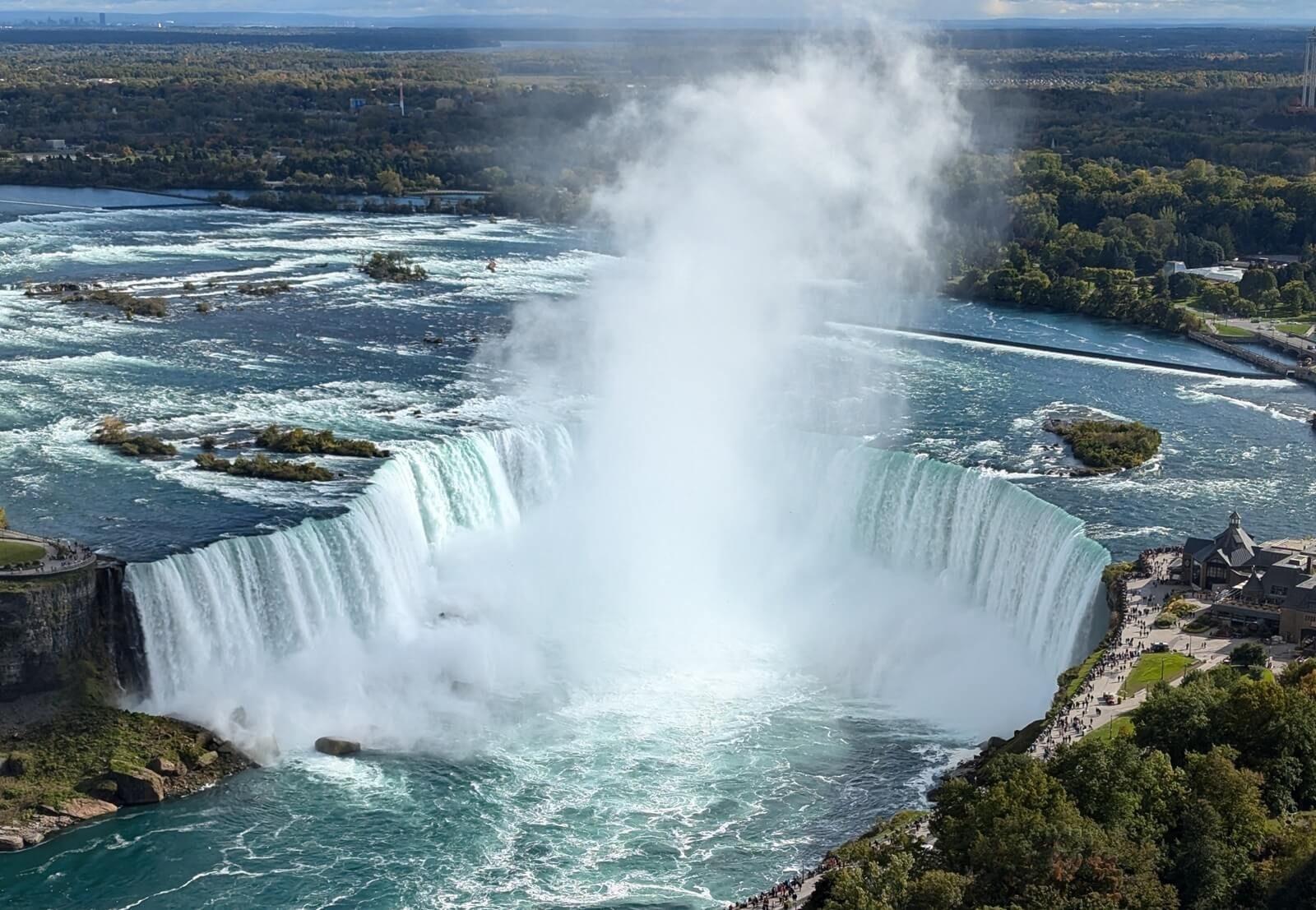 River flowing over the Niagra falls mist is rising hundreds of feet into the air.